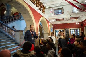 An image from the start of the first Digital Ghost Hunt, with the audience gathered at the steps of the main staircase at the Battersea Arts Centre, meeting the skeptical building manager for the first time